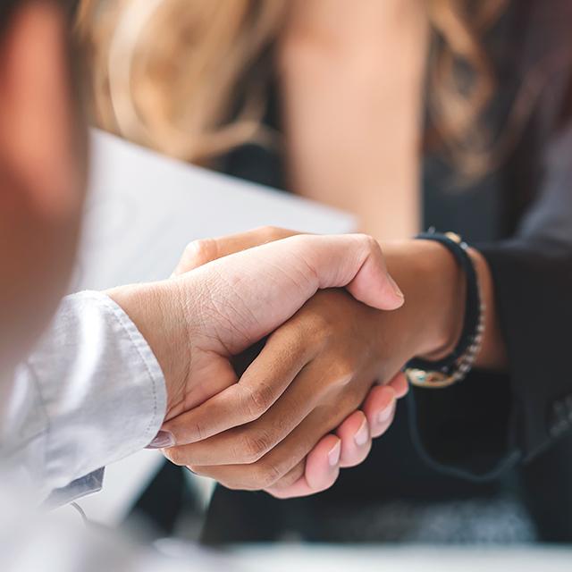 Two business professionals shake hands after an interview.