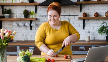 Overweight woman preparing vegetables