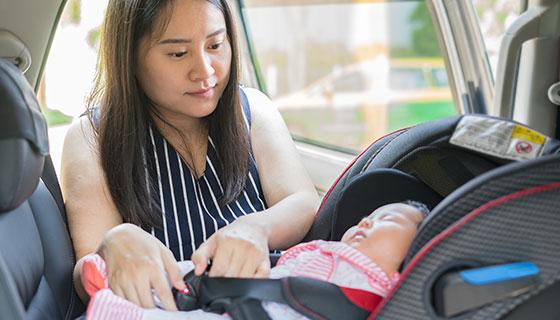 woman buckling baby in carseat