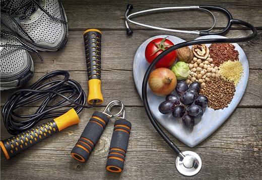 把健康食品放在心形盘子里，周围是锻炼器材