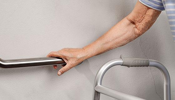 hand using a walker and safety railing teaser